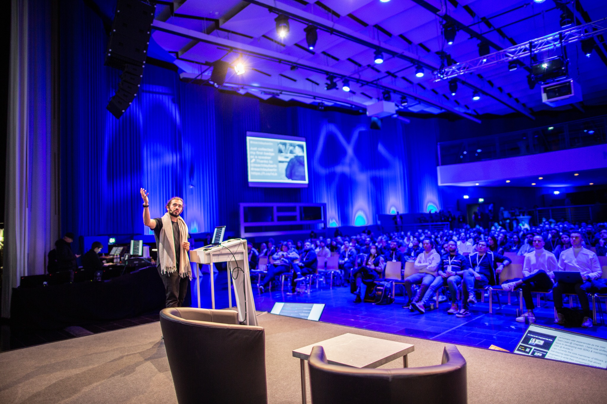 a photo showing a man standing at a stage talking at React Day Berlin conference
