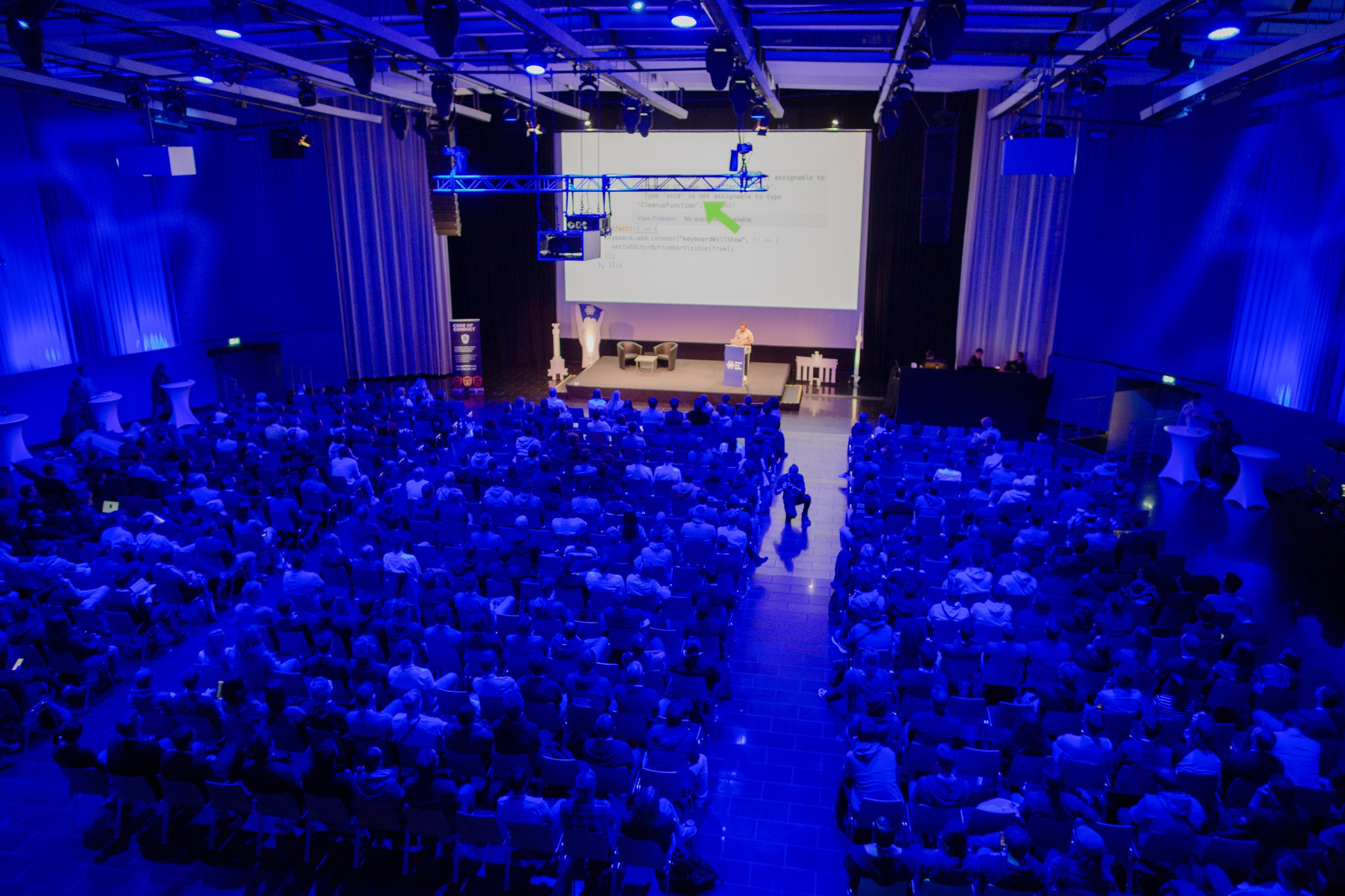 a photo showing a crowd listening to a talk on the stage during the React Day Berlin conference